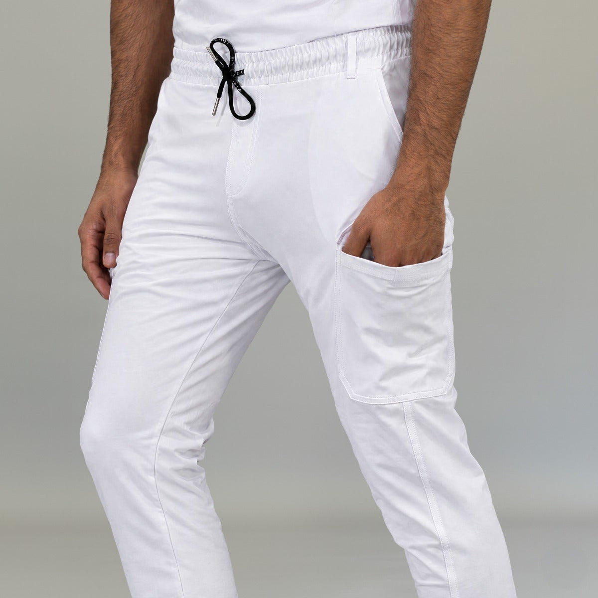 Detalle de cintura ajustable y bolsa cargo en jogger quirúrgico blanco hombre
