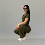 Modelo en cuclillas con jumpsuit Super Stretch Verde Olivo para mujer