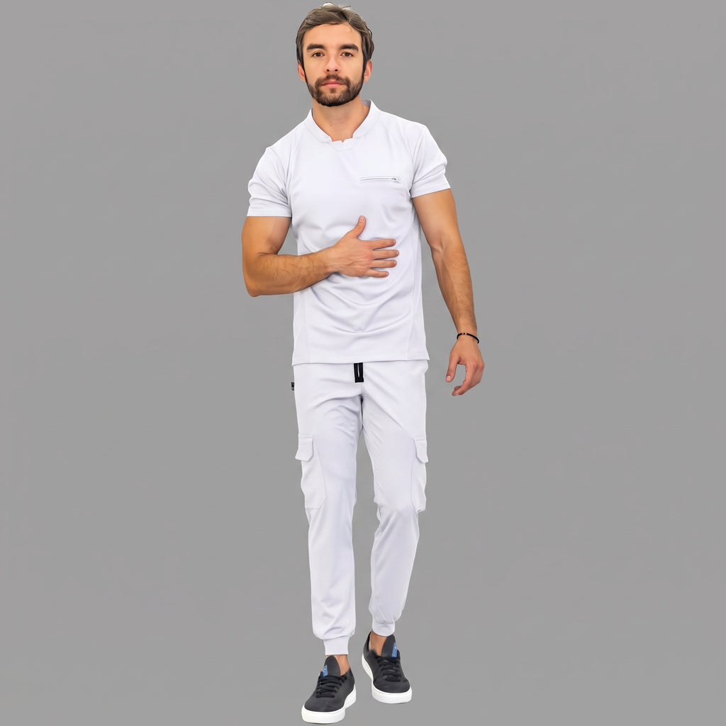 scrubs-blanco-cuerpo-completo.jpg: "Cuerpo completo de un hombre con el uniforme quirúrgico blanco Est. 910, combinando la filipina con el pantalón jogger blanco."